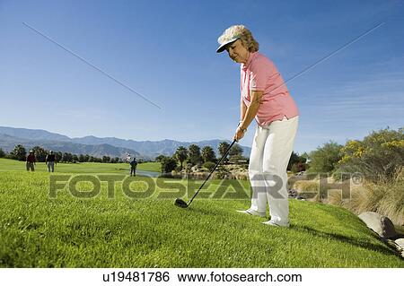Stock Photograph - Senior woman playing golf. Fotosearch