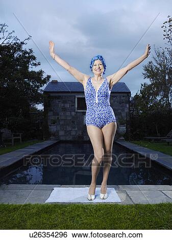 Stock Photograph - Senior woman posing by pool, (portrait). Fotosearch