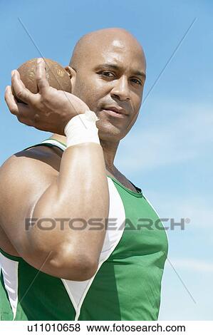 Shot Putter holding shot put, half-length View Large Photo Image Stock Photo - Shot Putter holding shot put, half-length. Fotosearch