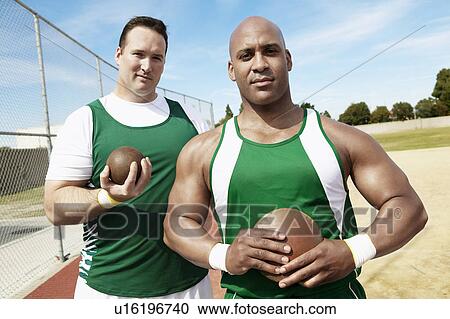 Stock Image - Shot Putters holding shot put and discus, half length. Fotosearch