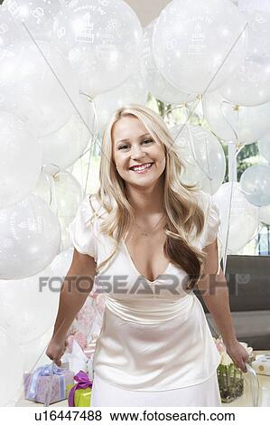 Stock Photo - Smiling Bride Holding Balloons at Bridal Shower. Fotosearch