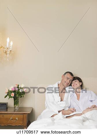 Stock Photo - Smiling couple relaxing in bed. Fotosearch