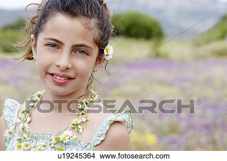 Smiling Pre-teen wearing necklace of flowers in field of flowers View Large Photo Image Picture - Smiling Pre-teen wearing necklace of flowers in field of flowers. Fotosearch