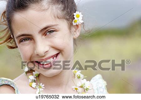 Smiling Pre-teen wearing necklace of flowers and flower behind ear, close-up View Large Photo Image Stock Image - Smiling Pre-teen wearing necklace of flowers and flower behind ear, close-up. Fotosearch
