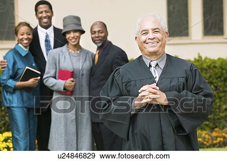 Smiling Preacher in church garden, worshipers in background, portrait View Large Photo Image Stock Photo - Smiling Preacher in church garden, worshipers in background, portrait. Fotosearch