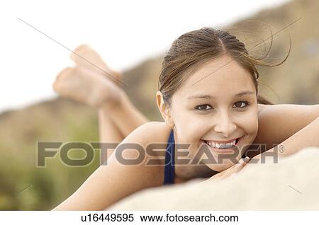 Stock Photography - Smiling Woman lying down on Beach, portrait. Fotosearch