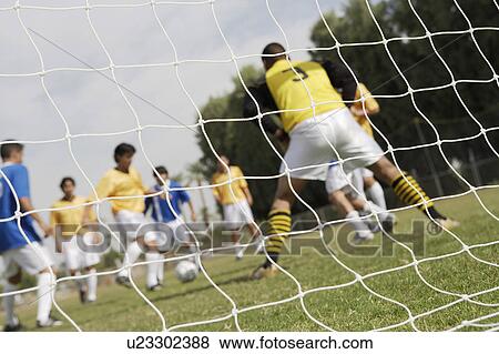 Soccer game seen through net, low angle view View Large Photo Image Stock Photo - Soccer game seen through net, low angle view. Fotosearch