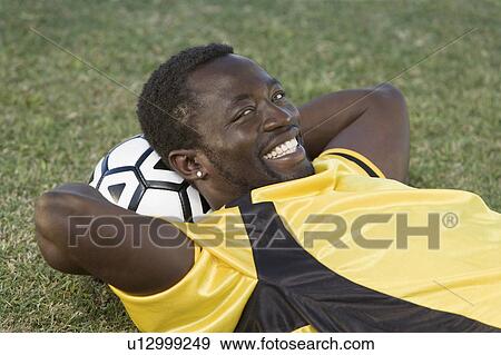 Soccer player lying with head on ball, portrait View Large Photo Image Stock Photo - Soccer player lying with head on ball, portrait. Fotosearch