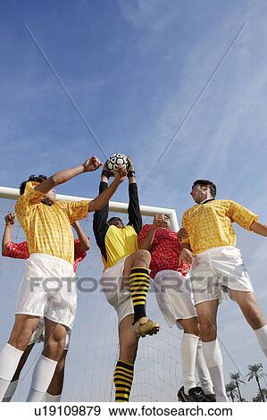 Stock Photo - Soccer players jumping for ball, low angle view. Fotosearch