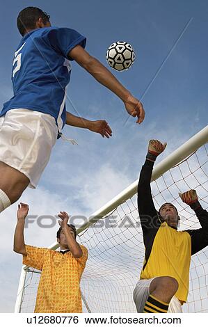 Stock Photograph - Soccer players jumping for ball. Fotosearch