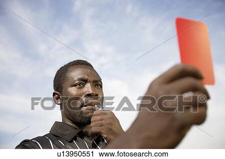 Soccer referee holding out red card and blowing whistle, portrait View Large Photo Image Stock Image - Soccer referee holding out red card and blowing whistle, portrait. Fotosearch