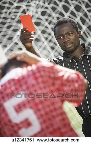 Soccer referee holding out red card, portrait View Large Photo Image Stock Image - Soccer referee holding out red card, portrait. Fotosearch