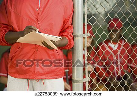 Softball coach writing on paper, mid section View Large Photo Image Stock Photo - Softball coach writing on paper, mid section. Fotosearch