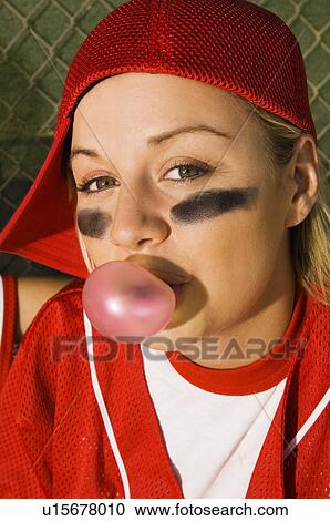 Stock Image - Softball player blowing bubblegum, portrait. Fotosearch