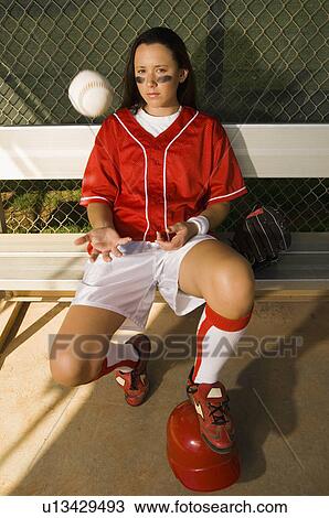 Softball player sitting on bench throwing ball, elevated view View Large Photo Image Stock Image - Softball player sitting on bench throwing ball, elevated view. Fotosearch