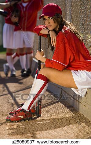 Softball player sitting on bench with bat, portrait View Large Photo Image Stock Photo - Softball player sitting on bench with bat, portrait. Fotosearch