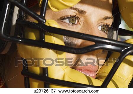 Stock Photo - Softball player wearing helmet, close-up of face. Fotosearch