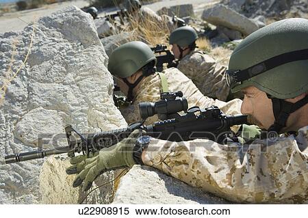 Soldiers with rifles hiding behind rocks View Large Photo Image Stock Photography - Soldiers with rifles hiding behind rocks. Fotosearch