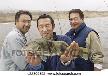 Stock Image - Sport fisherman displaying fish. Fotosearch