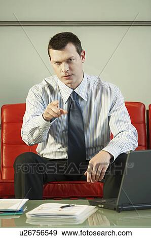 Stock Photo - Stern Businessman Pointing, portrait, front view. Fotosearch