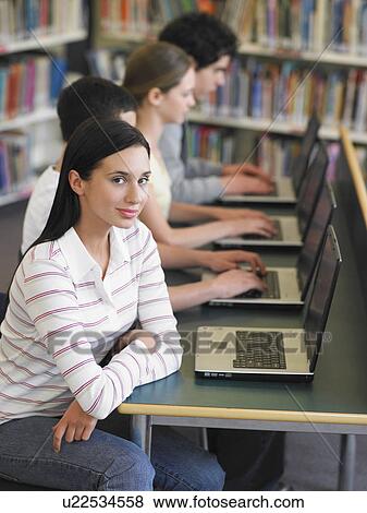 Stock Photo - Students using laptops in library, elevated view. Fotosearch