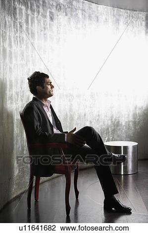 Stylish Man sitting, legs crossed, in metal room, side view View Large Photo Image Stock Image - Stylish Man sitting, legs crossed, in metal room, side view. Fotosearch