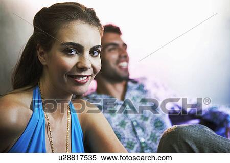 Stock Photography - Stylish Young Woman smiling, sitting next to mate, portrait. Fotosearch