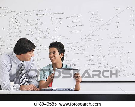 Teacher and student using laptop sitting in physics classroom View Large Photo Image Stock Photography - Teacher and student using laptop sitting in physics classroom. Fotosearch
