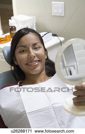 Stock Image - Teenage girl (13-16) at dentists, (portrait). Fotosearch