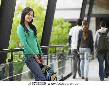 Teenage girl leaning against railing in corridor, portrait View Large Photo Image Stock Photo - Teenage girl leaning against railing in corridor, portrait. Fotosearch