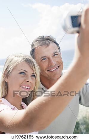 Stock Photography - Teenage Girl Taking Picture of Herself and Father. Fotosearch