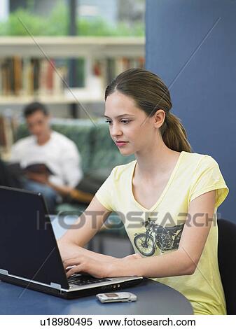 Teenage girl using laptop in library View Large Photo Image Stock Photography - Teenage girl using laptop in library. Fotosearch
