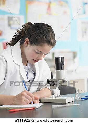 Teenage girl using microscope and taking notes in classroom View Large Photo Image Stock Image - Teenage girl using microscope and taking notes in classroom. Fotosearch