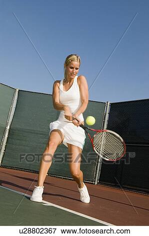 Stock Photo - Tennis Player Hitting Backhand on tennis court. Fotosearch