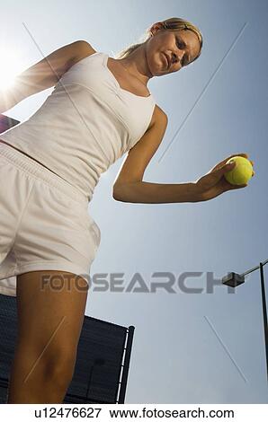 Stock Photo - Tennis Player holding ball in hand, Preparing to Serve, low angle view. Fotosearch