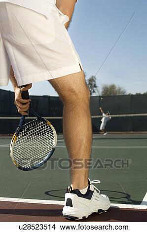 Picture - Tennis Player holding tennis racket, Waiting For Serve, low section, back view. Fotosearch