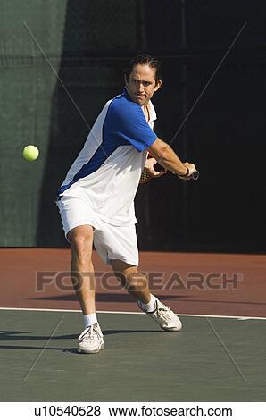 Stock Photo - Tennis Player on court, preparing to return tennis ball with backhand. Fotosearch
