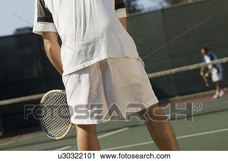 Stock Image - Tennis Player on court, Waiting For Serve, back view. Fotosearch