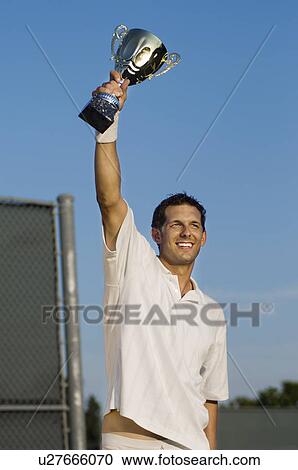 Tennis Player Proudly Holding Trophy in Air View Large Photo Image Stock Image - Tennis Player Proudly Holding Trophy in Air. Fotosearch