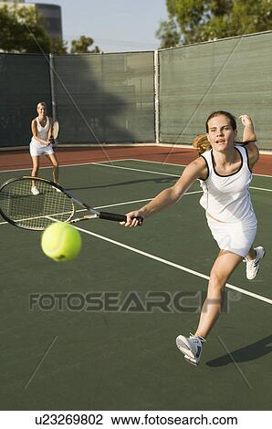 Tennis Player Reaching to hit tennis ball on tennis court View Large Photo Image Stock Image - Tennis Player Reaching to hit tennis ball on tennis court. Fotosearch