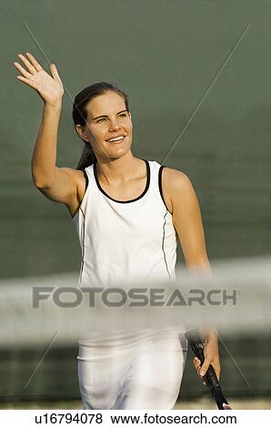 Tennis Player standing near net, arm raised and Waving View Large Photo Image Stock Photo - Tennis Player standing near net, arm raised and Waving. Fotosearch