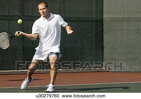 Tennis Player swinging tennis racket in forehand motion on tennis court View Large Photo Image Stock Image - Tennis Player swinging tennis racket in forehand motion on tennis court. Fotosearch