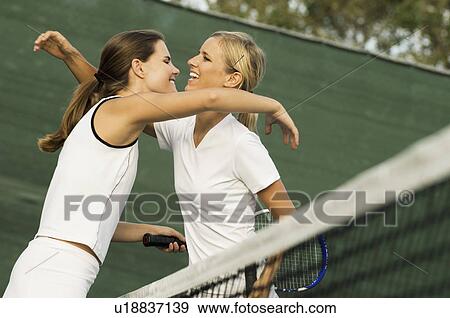 Stock Photo - Tennis Players Hugging Each Other over net After Match. Fotosearch