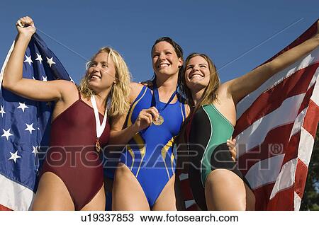 Three female swimmers celebrating victory, (low angle view) View Large Photo Image Stock Image - Three female swimmers celebrating victory, (low angle view). Fotosearch
