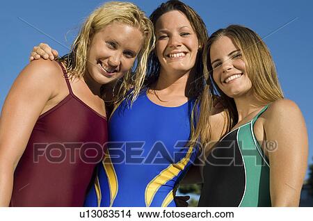 Picture - Three female swimmers smiling, (low angle view), (portrait). Fotosearch