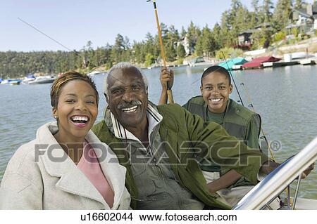 Three generation family on fishing trip, smiling, (portrait) View Large Photo Image Picture - Three generation family on fishing trip, smiling, (portrait). Fotosearch