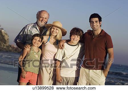 Three generation family standing together on beach at dusk, portrait View Large Photo Image Stock Photo - Three generation family standing together on beach at dusk, portrait. Fotosearch
