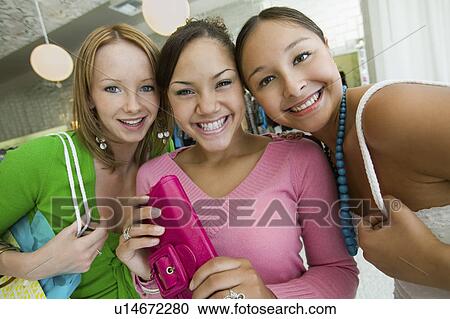 Stock Image - Three Girls Shopping at Boutique, portrait. Fotosearch