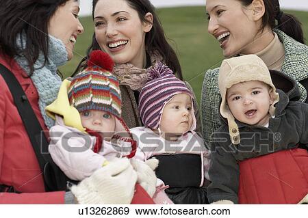 Three mothers with babies in slings chatting outdoors View Large Photo Image Stock Photo - Three mothers with babies in slings chatting outdoors. Fotosearch