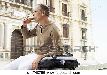 Tourist sitting in town square in Granada Drinking Latte, side view View Large Photo Image Stock Photograph - Tourist sitting in town square in Granada Drinking Latte, side view. Fotosearch